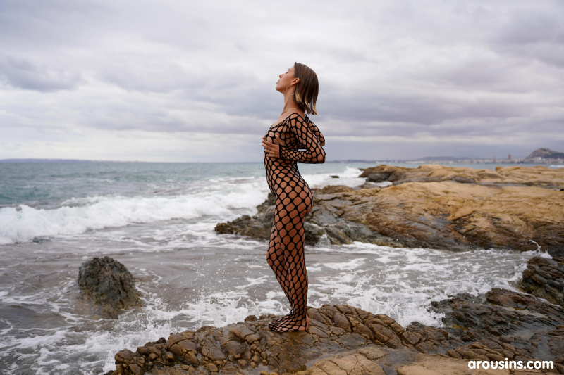 Avery poses nude on rocky coast